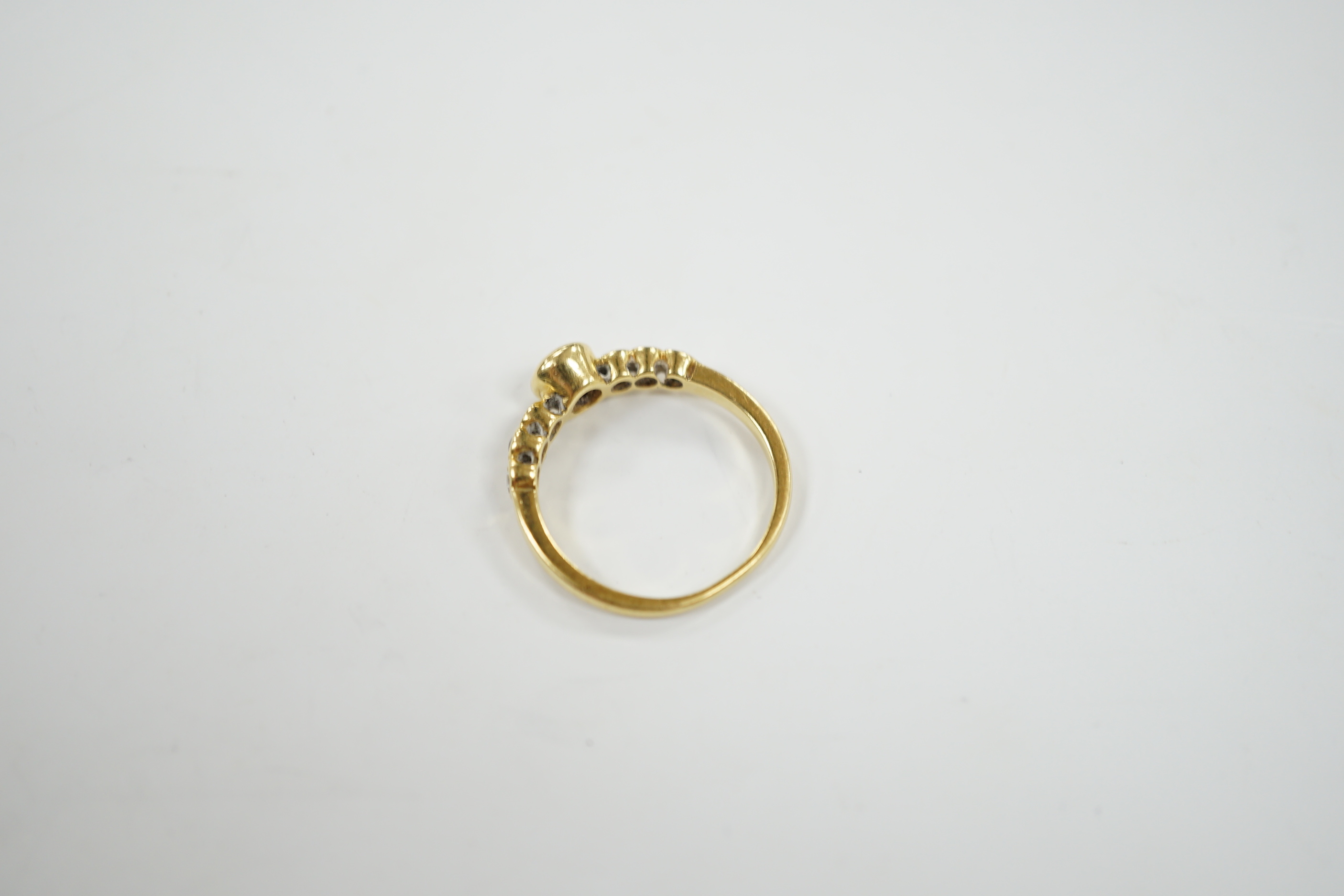 A 750 yellow metal and seven stone diamond set half hoop ring, size O, gross weight 3.6 grams.